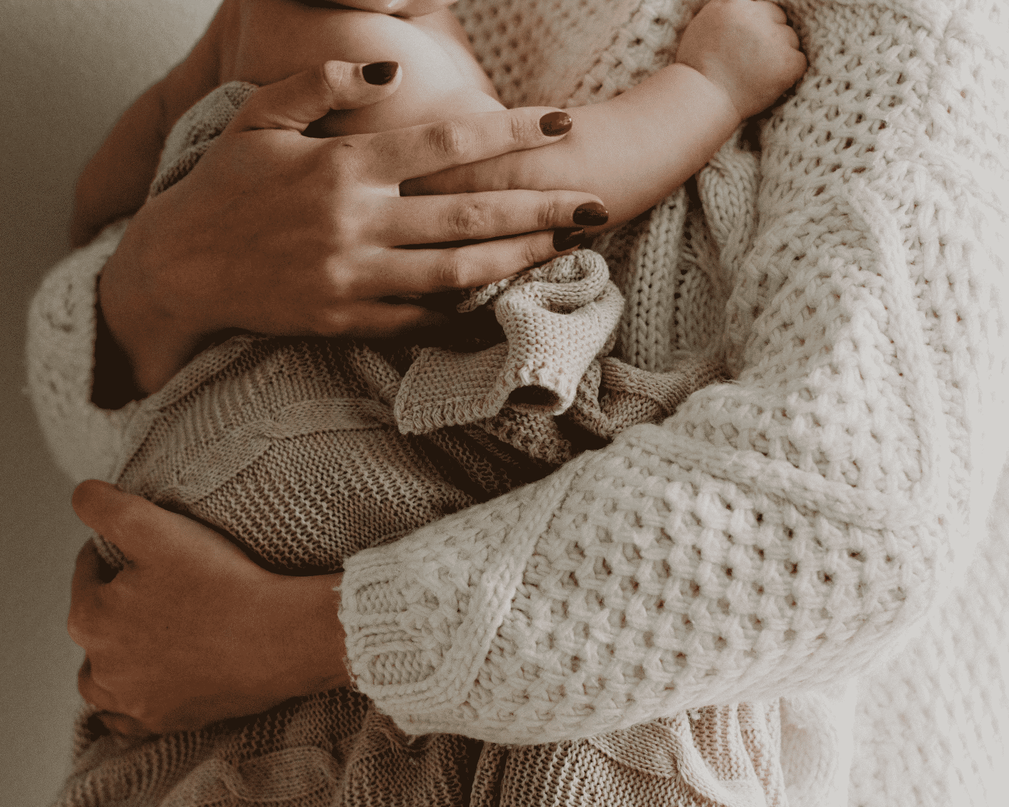Mutter hält Baby im Arm zeigt wie eine Schwangerschaftsmassage die Bindung fördern kann